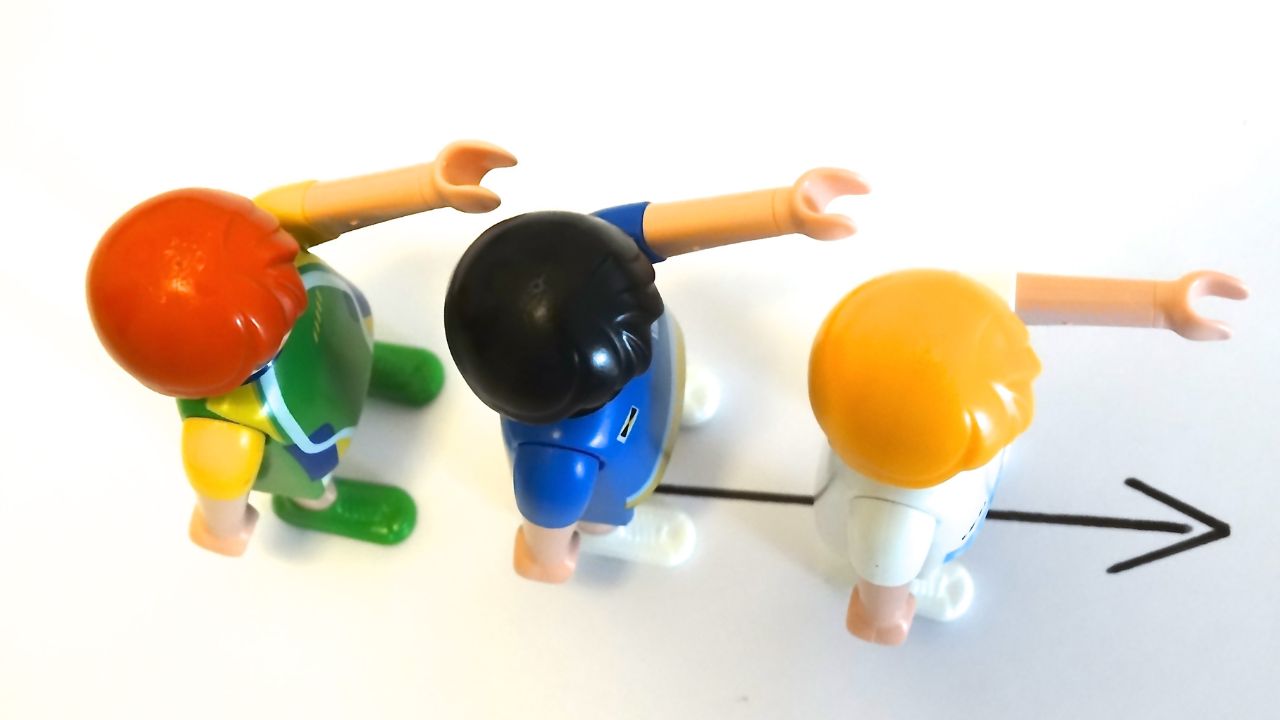 Top down view of 3 playmobil figures in a line